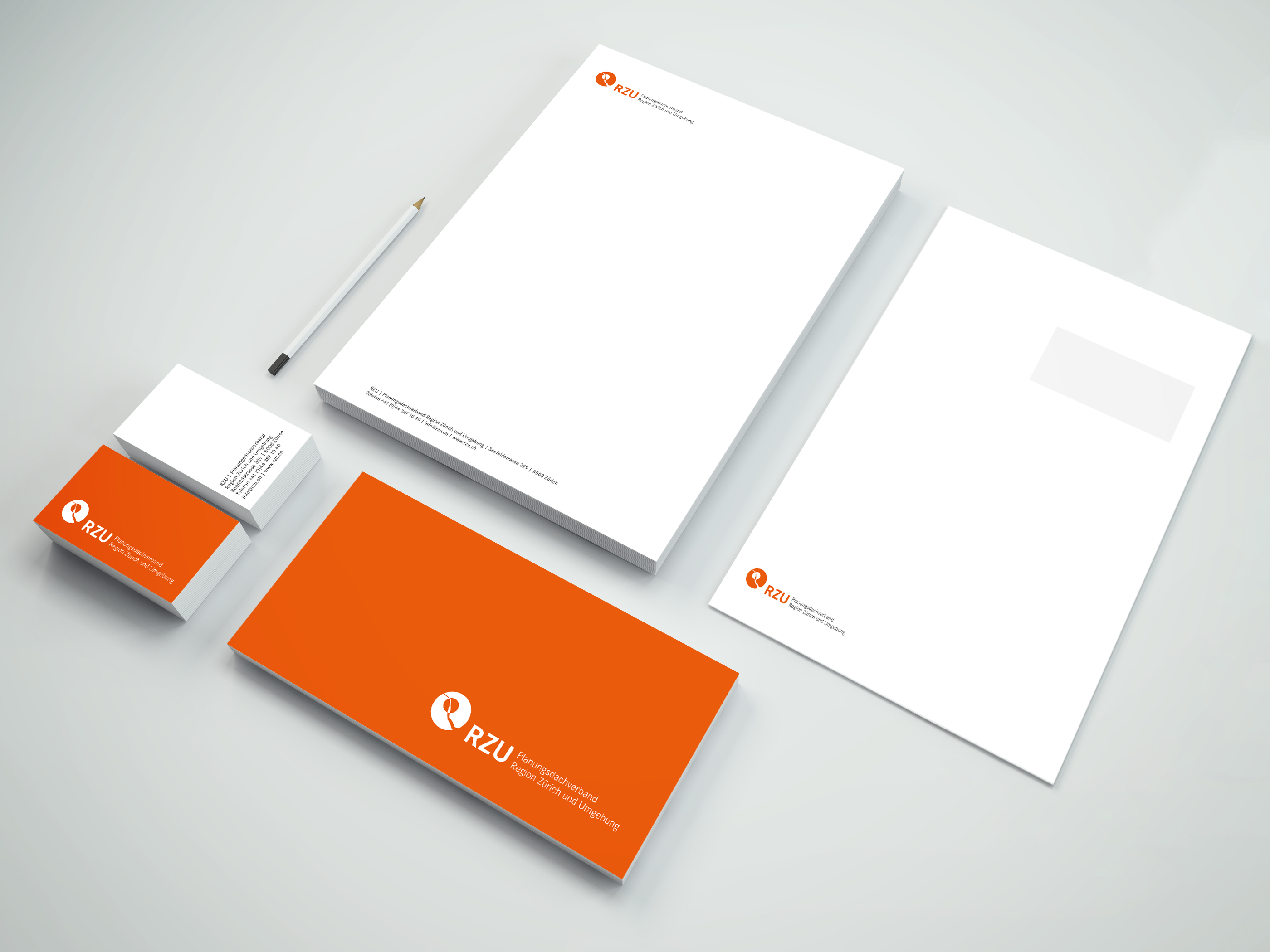 Geschäftsdrucksachen des RZU mit Briefpapier, Visitenkarten und Couverts im Corporate Design mit orangefarbenem Logo.