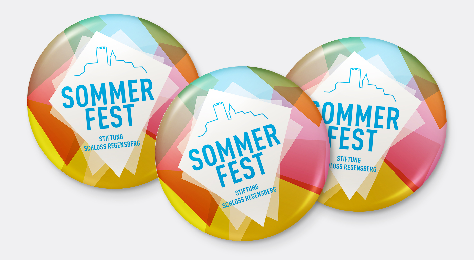 Bunte Buttons mit dem Schriftzug "Sommerfest Stiftung Schloss Regensberg"