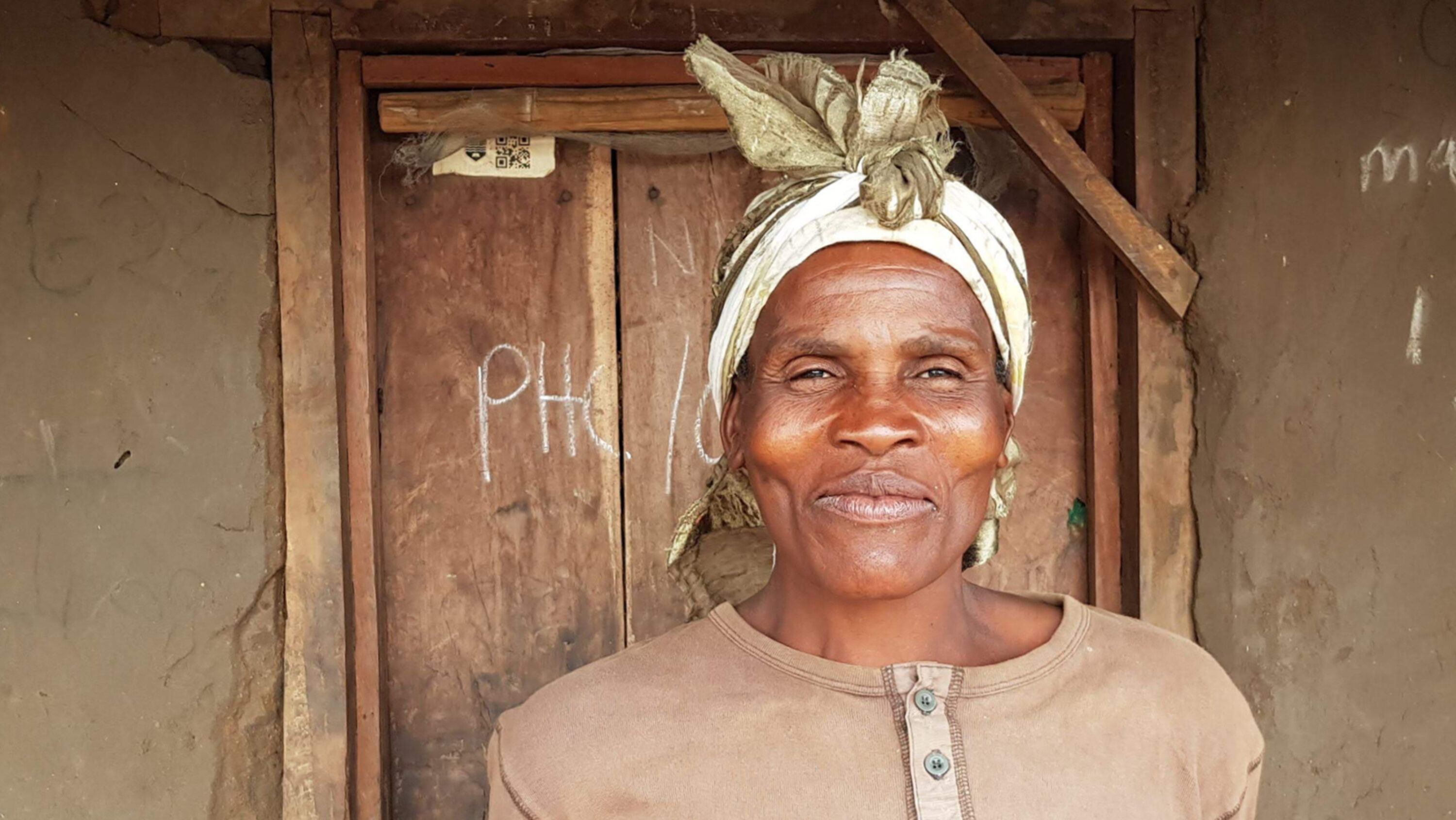 Porträt einer Frau mit Kopftuch vor einer Holztür